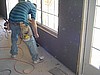 Workers fasten sheetrock to the interior